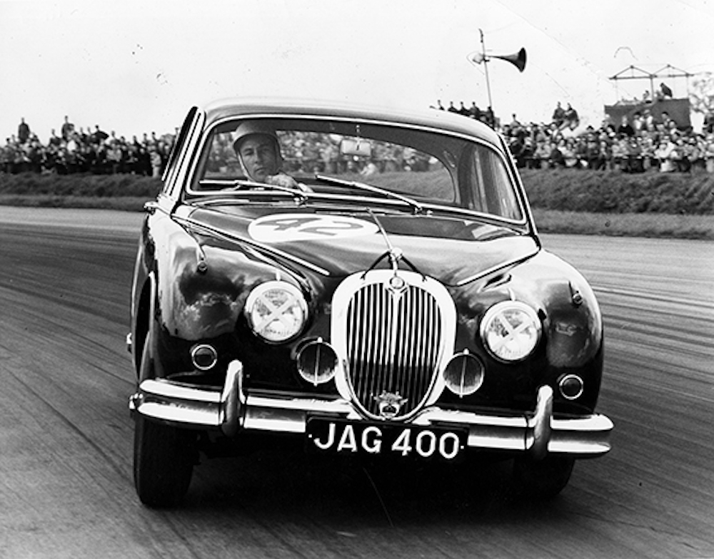 Stirling Moss au volant d’une Jaguar Mark 2 lors d’une course à Silverstone en 1960.(copyright archives AgrippA mediA /// archives Jaguar)